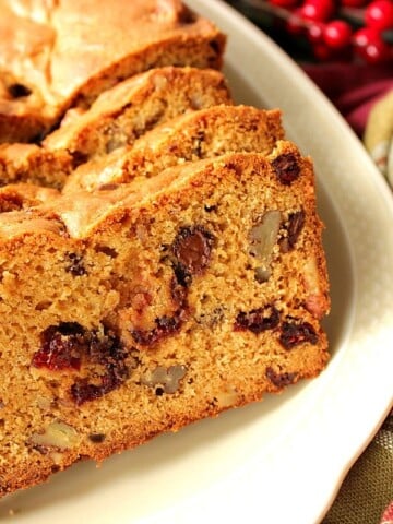 Quick Bread with Cranberries, Chocolate and Pecans on a serving plate.