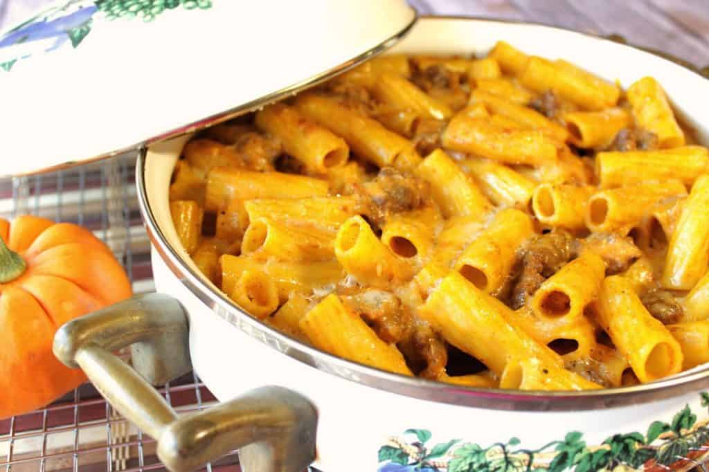 Pumpkin Cream Pasta with Bratwurst is a delicious way to bring pumpkin to the dinner table in a savory way! - Kudos Kitchen by Renee - www.kudoskitchenbyrenee.com Pumpkin Cream Pasta with bratwurst in a casserole dish and a lid