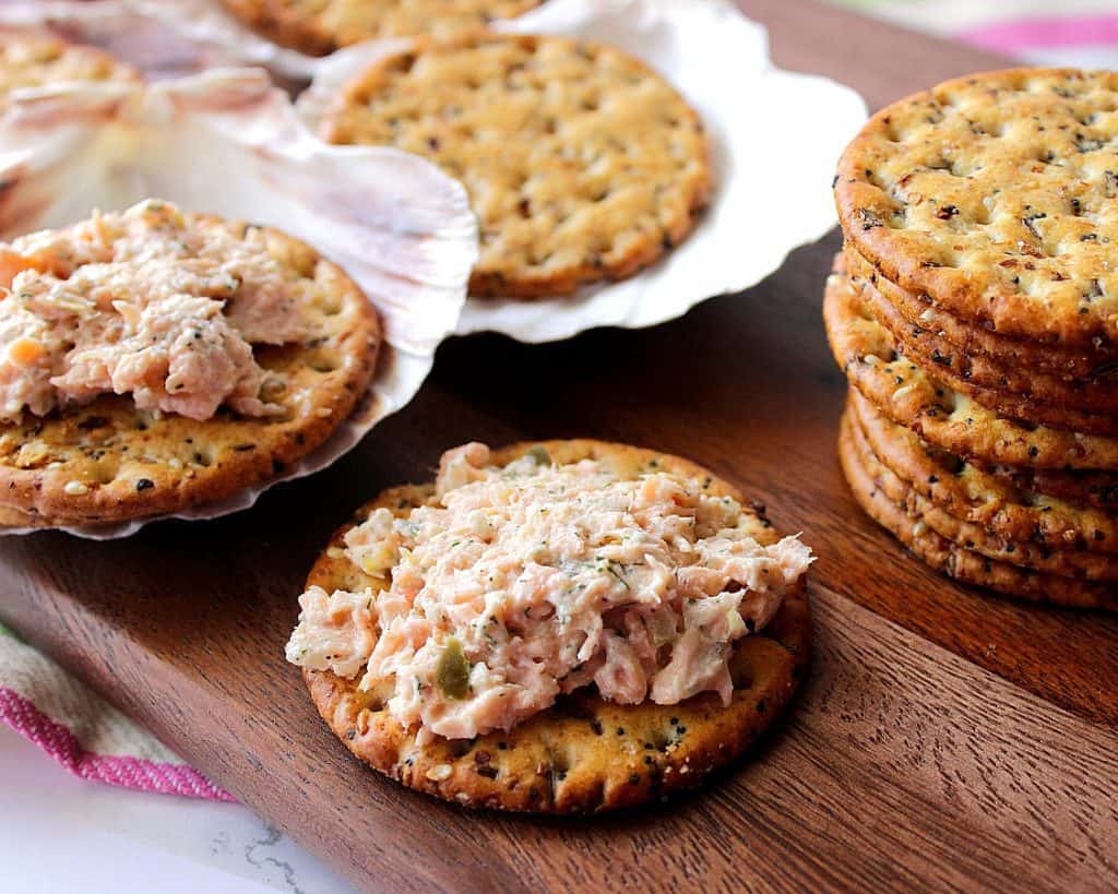 Baked Salmon Salad Spread Appetizer on crackers and in a seashell.