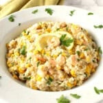 Creamy Risotto with Sweet Corn and Shrimp in a white bowl topped with parsley.