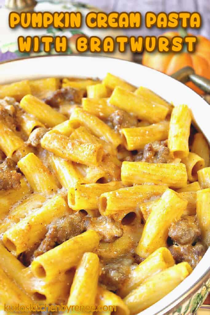 A vertical closeup photo of pumpkin cream pasta with bratwurst in a casserole dish and a title text overlay graphic