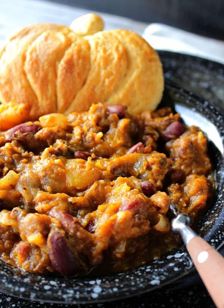Closeup vertical photo of Slow Cooker Butternut Squash Chili with a pumpkin shaped biscuit.