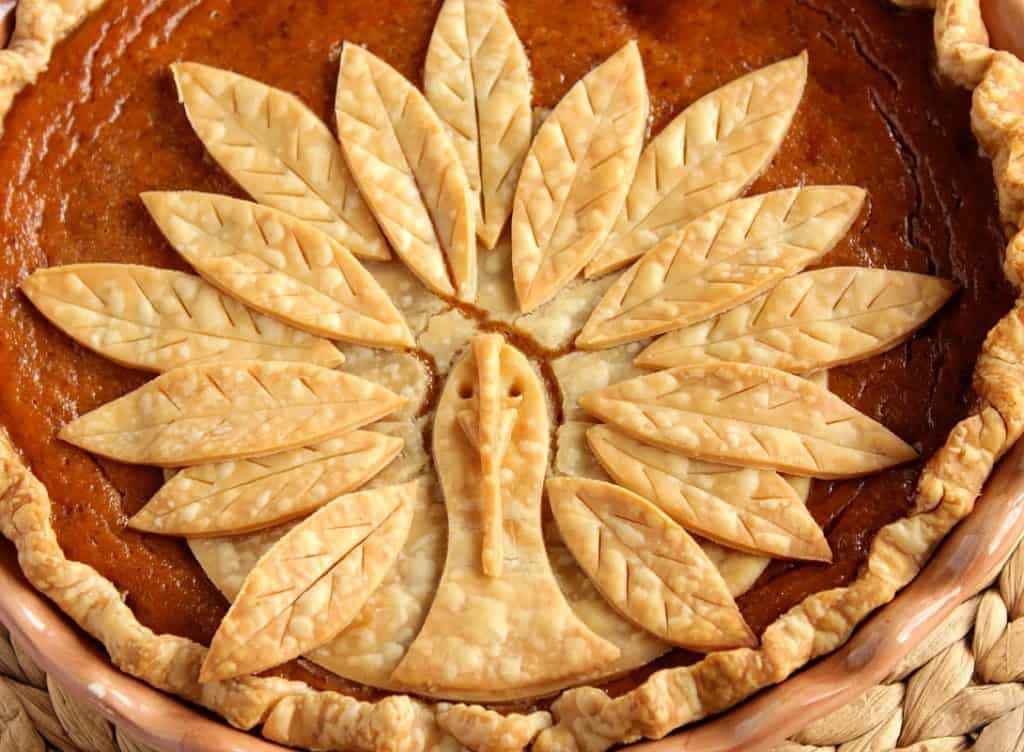 Closeup photo of a Turkey Crust Pumpkin Pie made out of pie dough on top of a pumpkin pie.