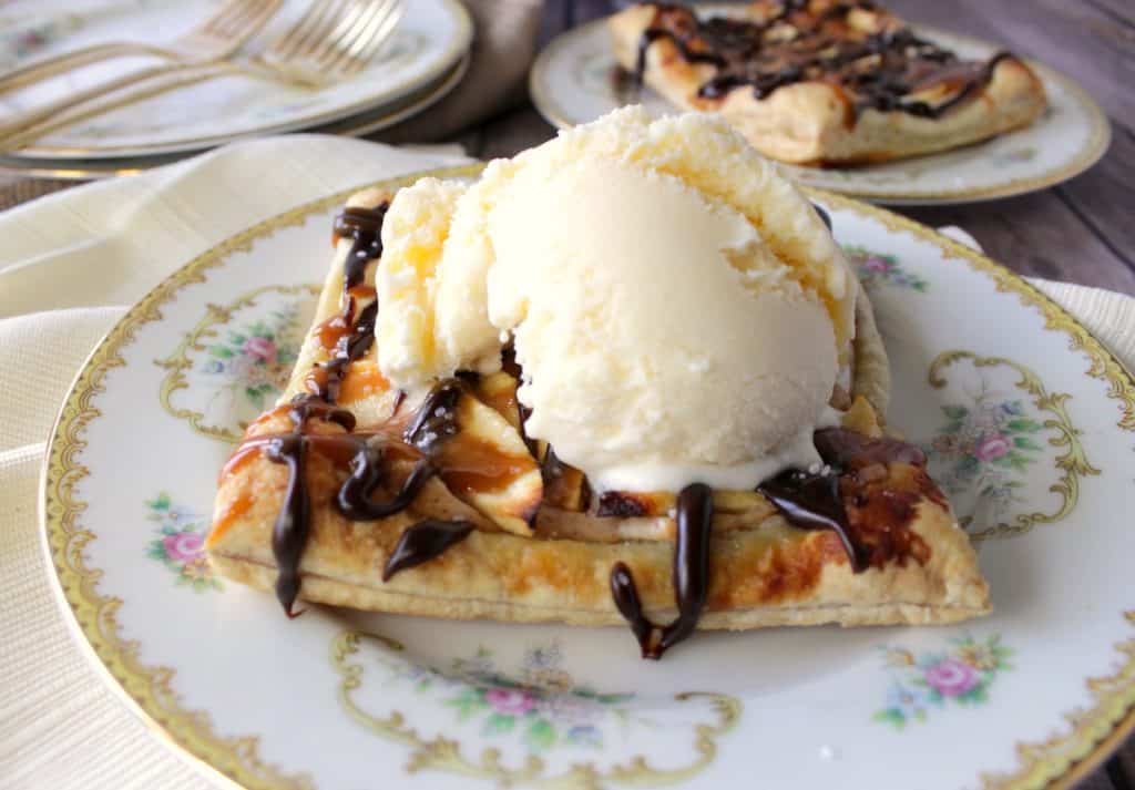 A Puff Pastry Apple Square on a china plate with a scoop of vanilla ice cream on top.