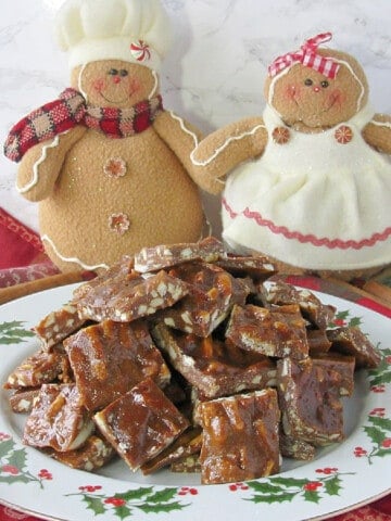 A plate of Gingerbread Toffee with two ginger people in the background.