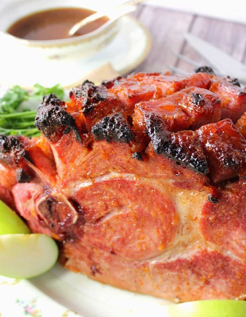 Spiced Apricot Mustard Glazed Ham Overhead picture of an Apricot Glazed Ham with Mustard and a gravy boat in the background.