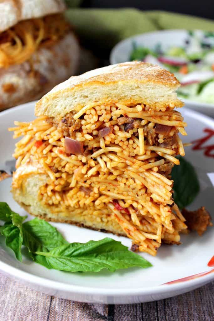 A closeup photo of a slice of Spaghetti Stuffed Garlic Bread