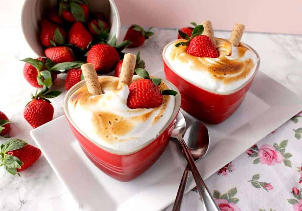 Treat your honey to a Deliciously Charming Individual Baked Alaska for Two this Valentine's Day, and you'll both be falling in love all over again! Baked Alaska for two with two spoons and a bucket of strawberries.