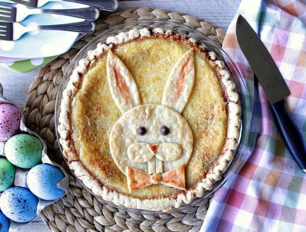 An overhead photo of an Easter Bunny Pie with colored eggs and a colorful napkin.