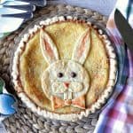 An overhead photo of an Easter Bunny Pie with colored eggs and a colorful napkin.