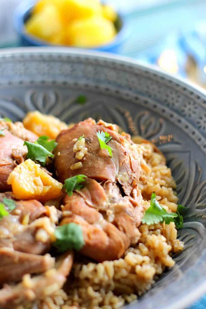 Tasty looking Pineapple Chicken Thighs in a bowl with pineapple and rice.