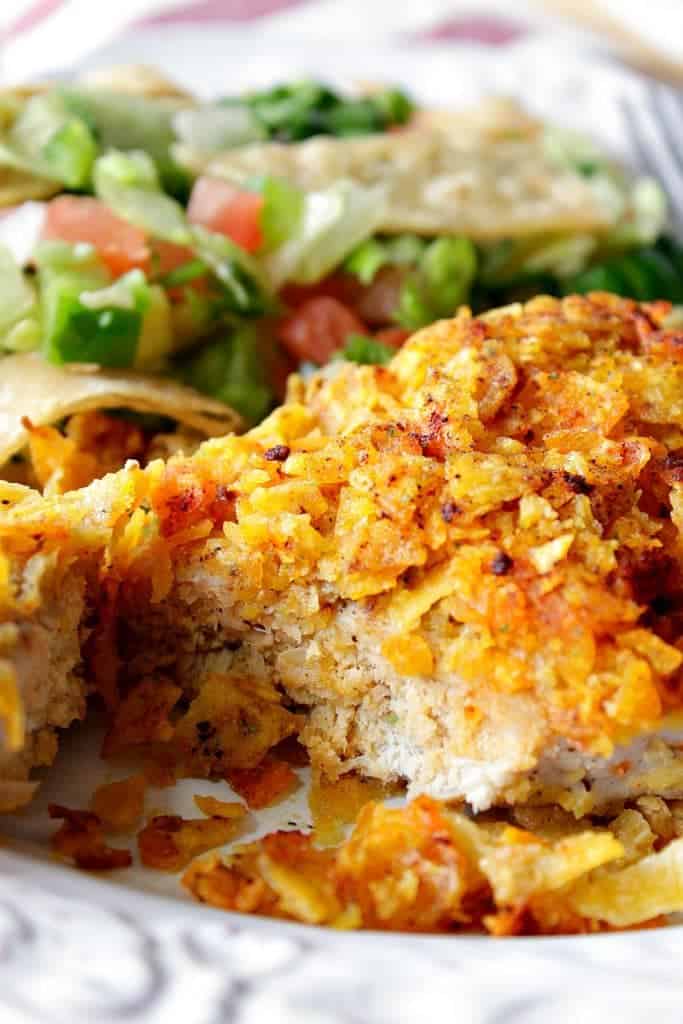 Closeup photo of a Crunchy Cool Ranch Pork Chop with a salad in the background.