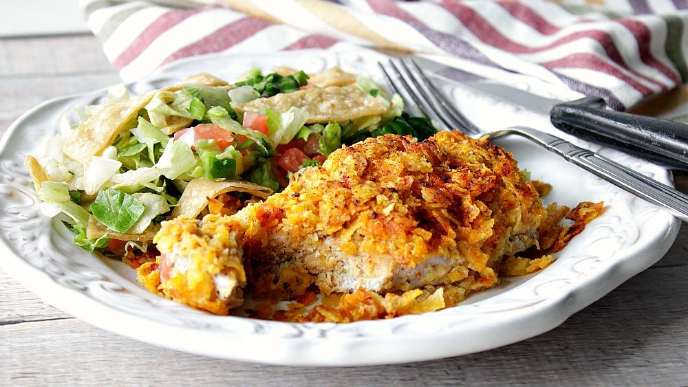 Cool Ranch Pork Chop on a white plate with a salad, fork and knife.