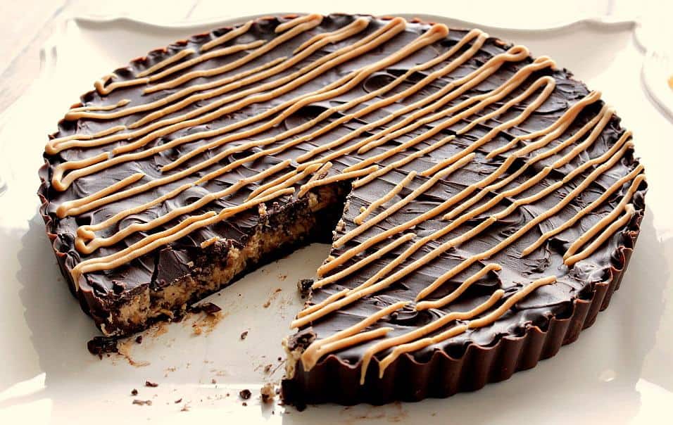 Giant Peanut Butter Cup on a white square plate with a wedge slice cut out.