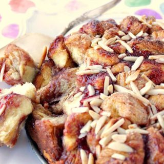 A loaf of Raspberry Spiced Monkey Bread on a platter with two pieces taken out.
