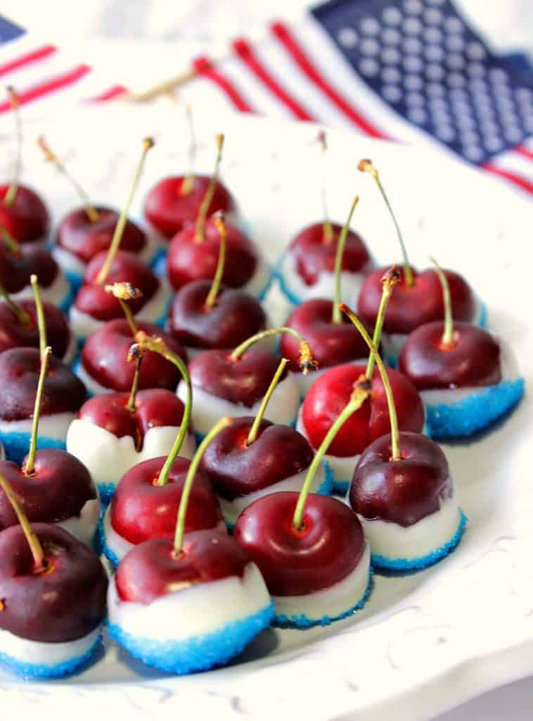 Closeup vertical photo of Red White and Blue Sugared Cherries on a white plate