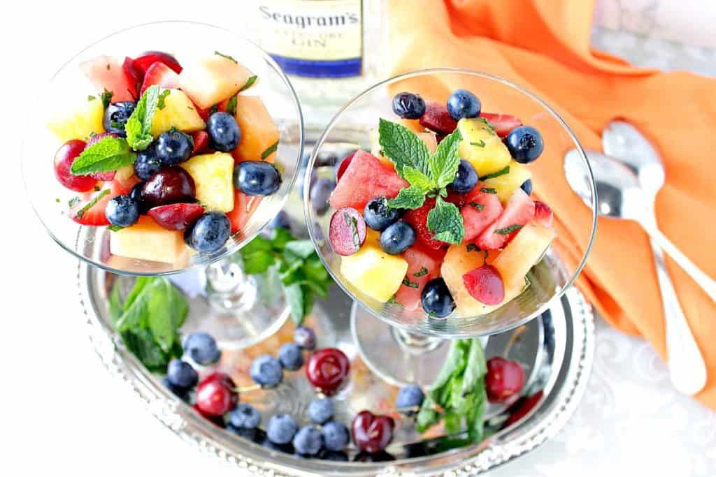 Overhead photo of boozy fruit cocktail in martini glasses. New year's eve appetizer and drinks recipe roundup.