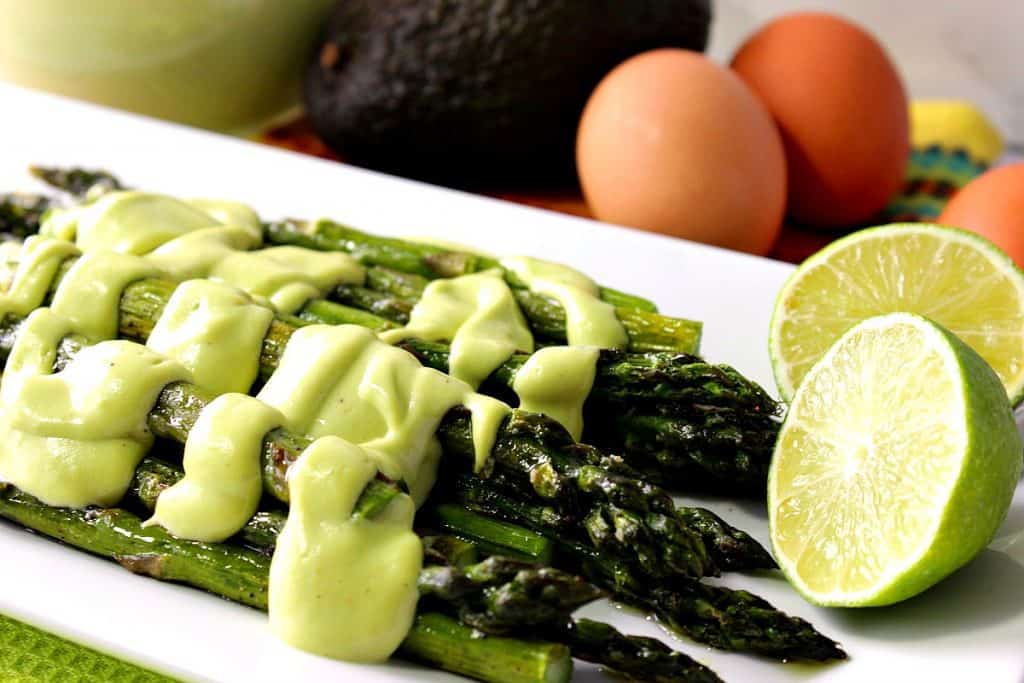 Oven Roasted Asparagus with Creamy Avocado Hollandaise Sauce over top. BBQ side dish recipes roundup.