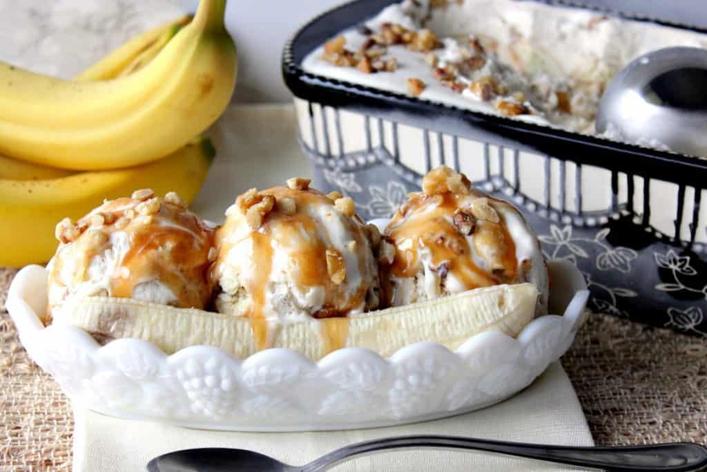 No Churn Banana Walnut Ice Cream in an ice cream dish with bananas and caramel sauce.