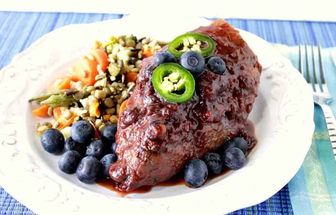 Blueberry Chicken Chile Skillet Dinner with Fresh Blueberries and Jalapeno on a white dinner plate with a blue napkin
