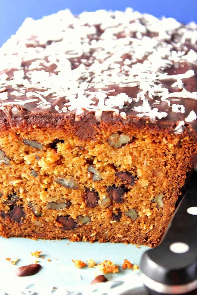 Close up slice of Chocolate Chip quick bread with pecans, coconut and chocolate ganache on top.