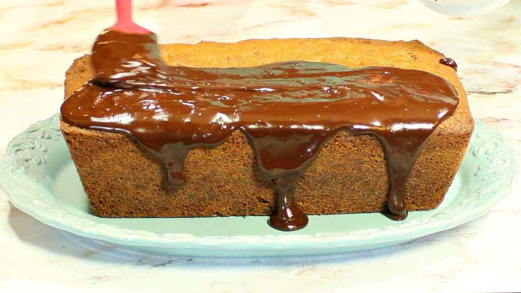 Spreading ganache on a chocolate chip dessert loaf. - kudoskitchenbyrenee.com