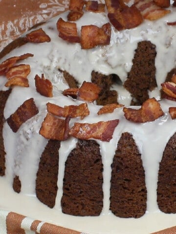 An iced Bacon Root Beer Bundt Cake with bacon on top.