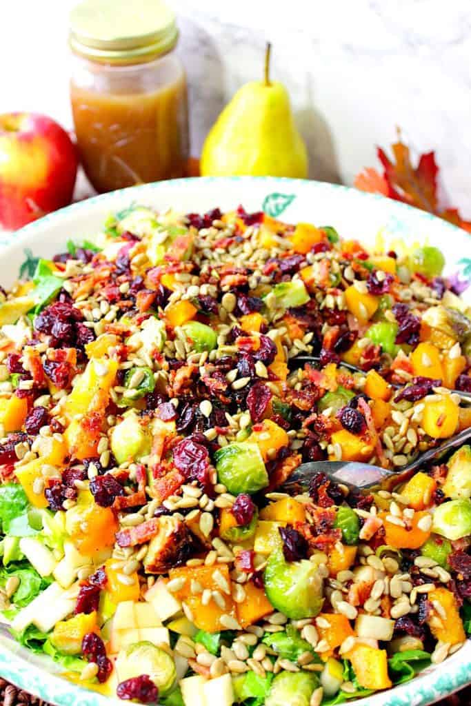 Vertical photo of an autumn harvest fruit and vegetable salad with butternut squash and Brussels sprouts.