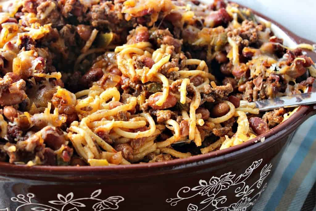 An oval brown casserole dish filled with spaghetti western casserole with ground beef and pasta