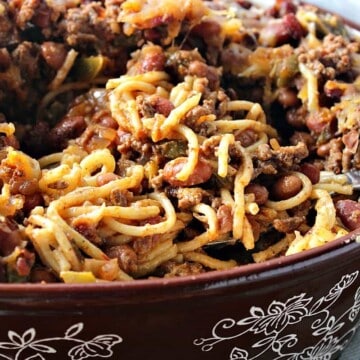 An oval brown casserole dish filled with spaghetti western casserole with ground beef and pasta