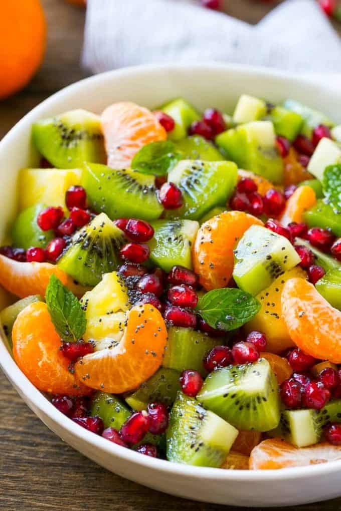 Closeup of colorful fruit salad. Oranges, Kiwi, pomegranate, poppy seeds. Healthy salad recipe roundup.