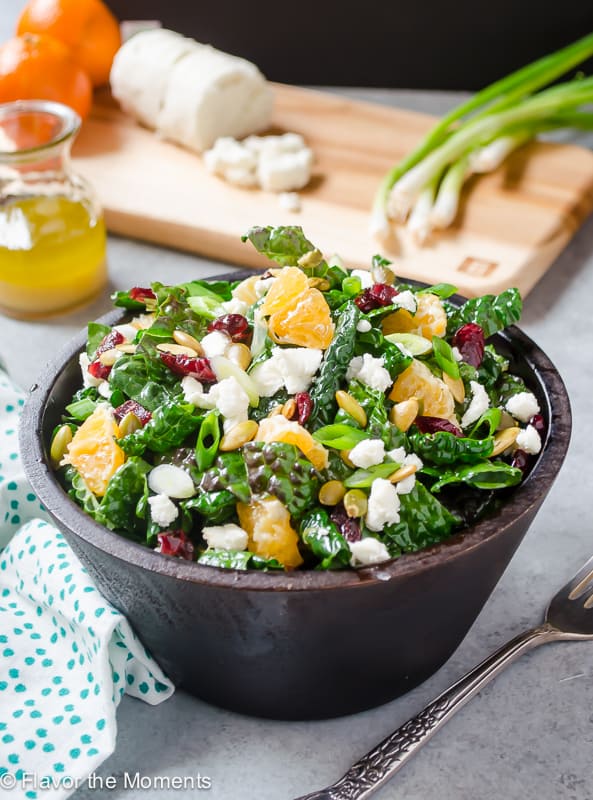 Kale, cranberry, feta, and orange in a colorful salad for healthy salad recipe roundup.