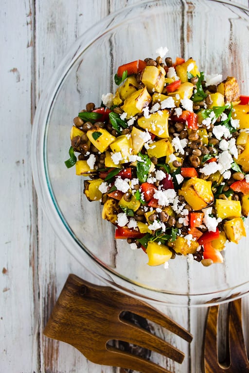 Clear bowl filled with a colorful salad with yellow, green, white and red ingredients. Healthy Salad Recipe Roundup.