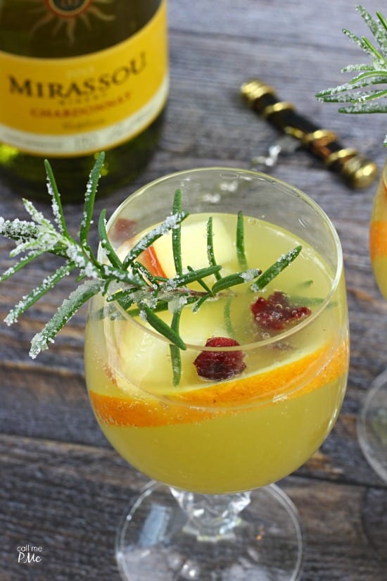 Closeup of a cocktail with fresh fruit and rosemary. New Years eve appetizers and drinks recipe roundup.