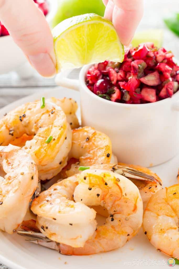 Closeup of cooked shrimp with seasonings on a plate. New Years eve appetizers and drinks recipe roundup.