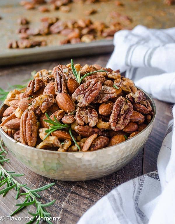 Closeup of nuts in a dish with rosemary. New Years eve appetizers and drinks recipe roundup.