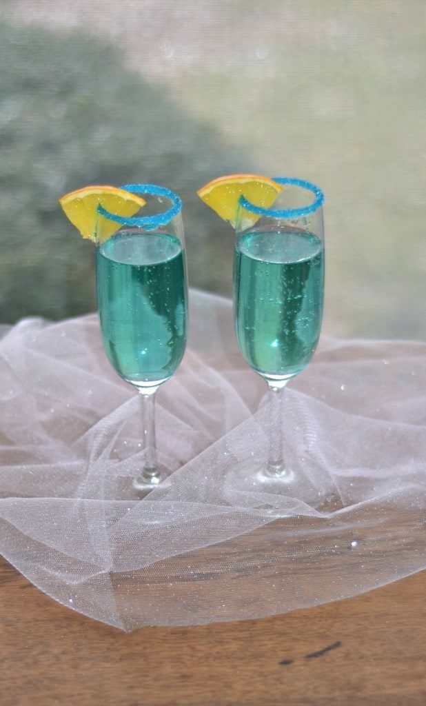 Two blue cocktails with sparkles. New Years eve appetizers and drinks recipe roundup.