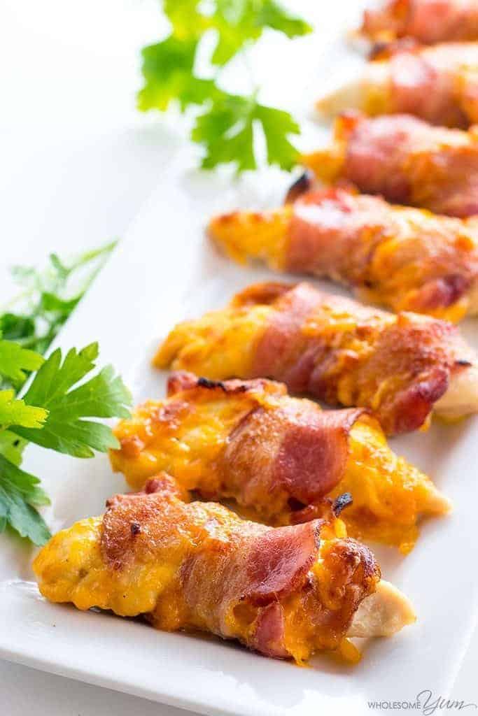 Closeup photo of chicken tenders wrapped in bacon. New Years eve appetizers and drinks recipe roundup.