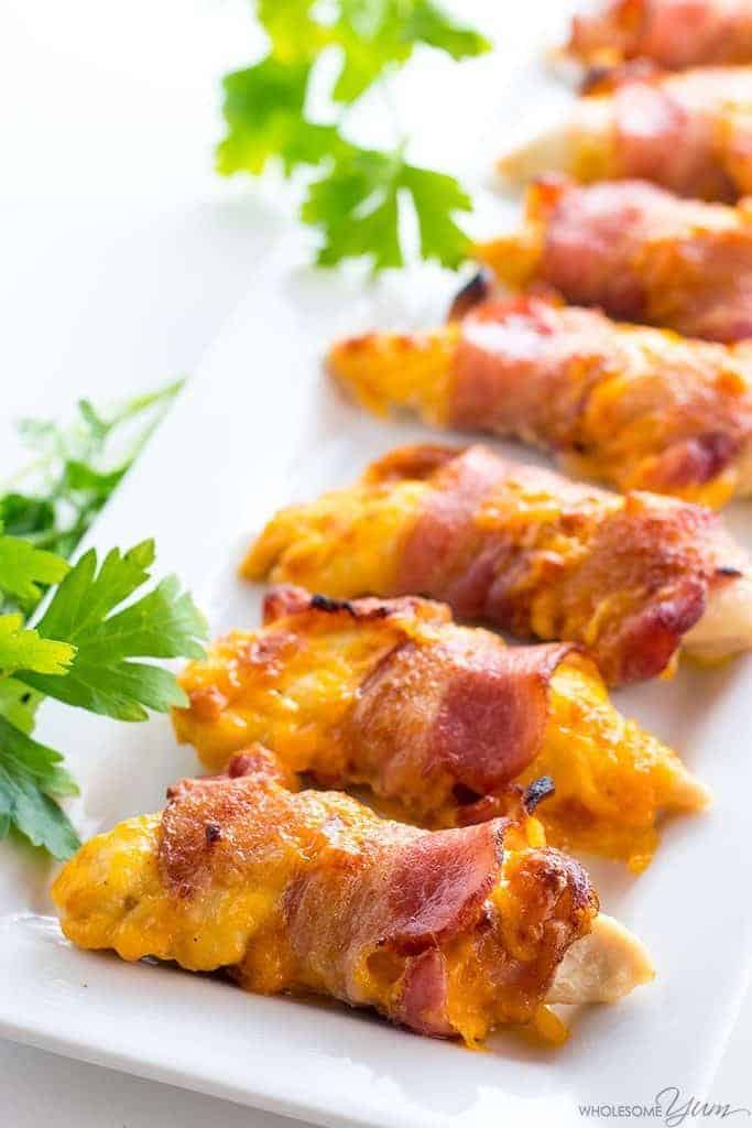 Closeup photo of chicken tenders wrapped in bacon. New Years eve appetizers and drinks recipe roundup.