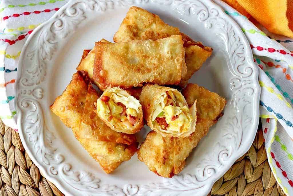 Overhead picture of scrambled egg rolls on a white plate with a bright yellow napkin.