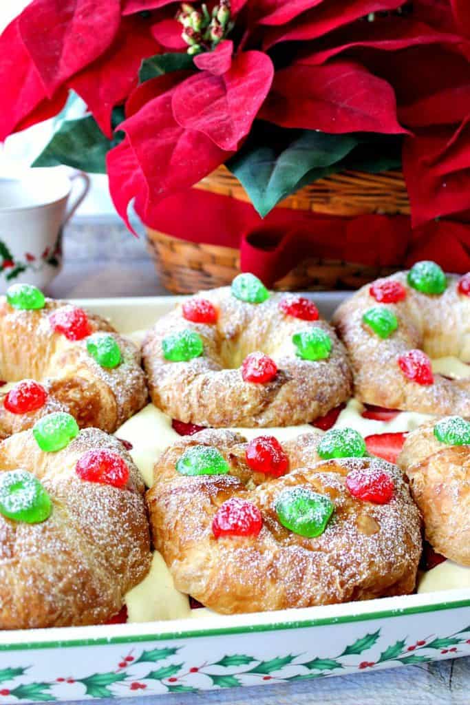 No-Bake Eggnog Pastry Cream Filled Croissants in a pretty holiday casserole dish with poinsettias in the background.