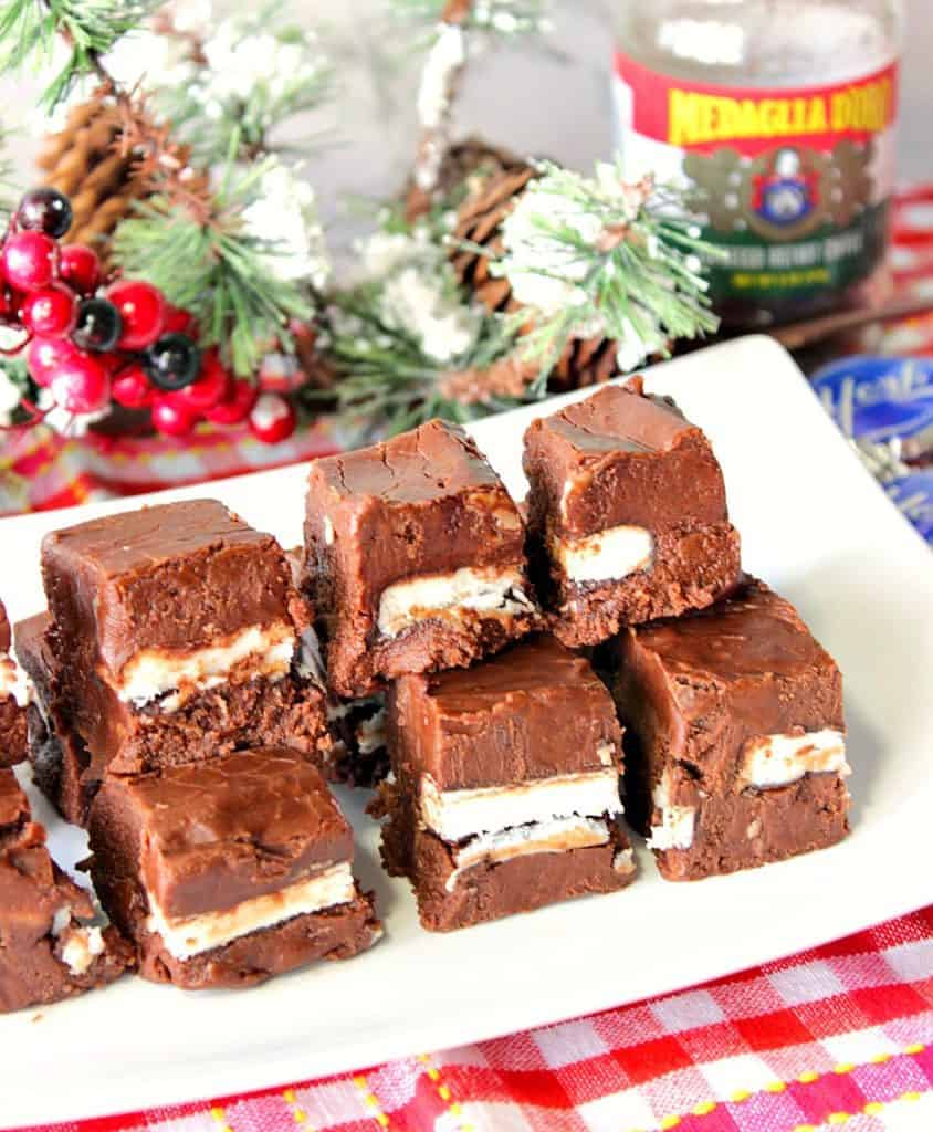 Layered Chocolate Espresso Peppermint Fudge on a white plate sitting on a red and white tablecloth. 