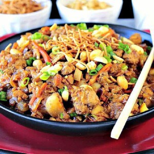 A black bowl filled with Ground Pork Egg Roll Bowl topped with peanuts and scallions.
