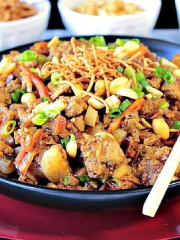 A black bowl filled with Ground Pork Egg Roll Bowl topped with peanuts and scallions.