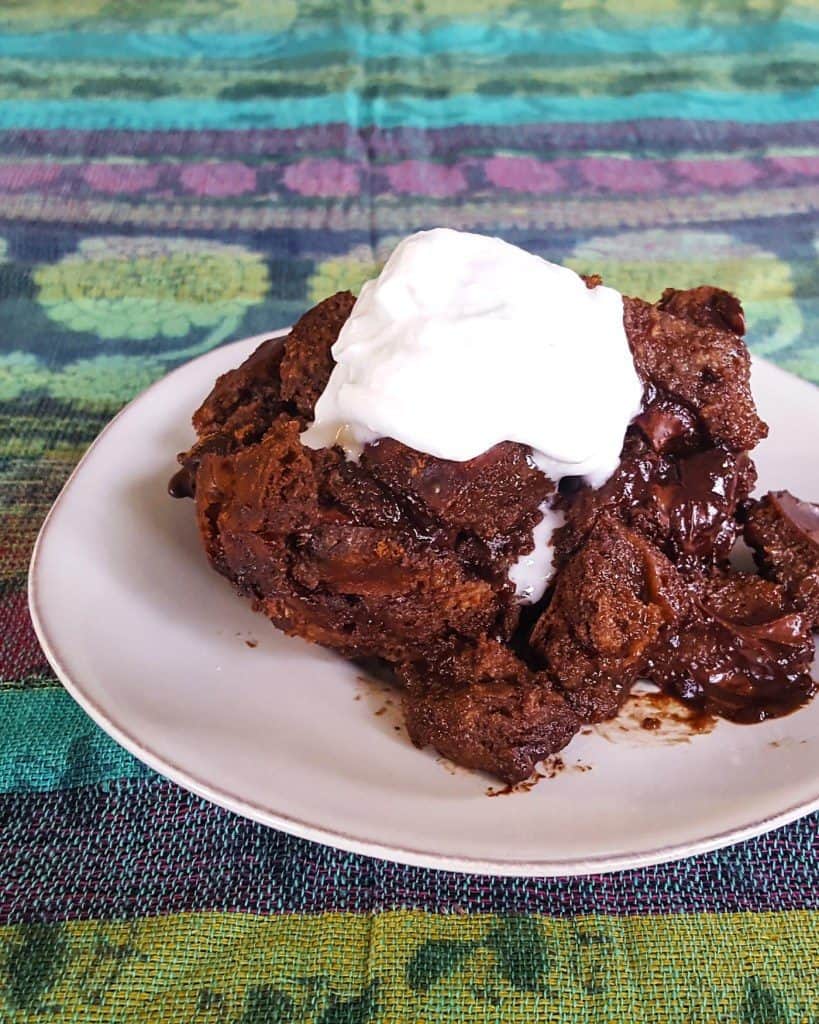 Gooey chocolate cake with whipped cream on a plate for best chocolate dessert recipes collection