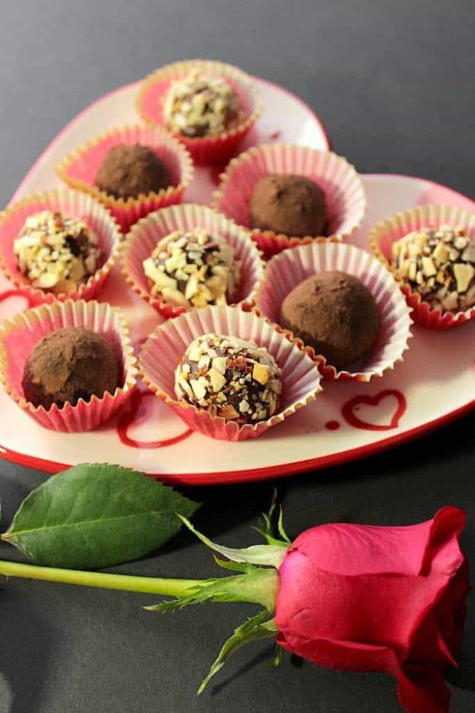 Chocolate avocado truffles on a heart plate for chocolate dessert recipes for valentine's day roundup.