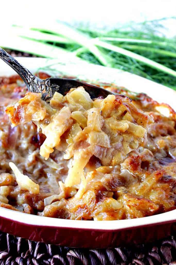 A closeup photo of a serving spoon dishing up some cheesy fennel gratin.