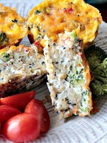 A healthy Quinoa Veggie Egg White Cup on a white plate with tomatoes.