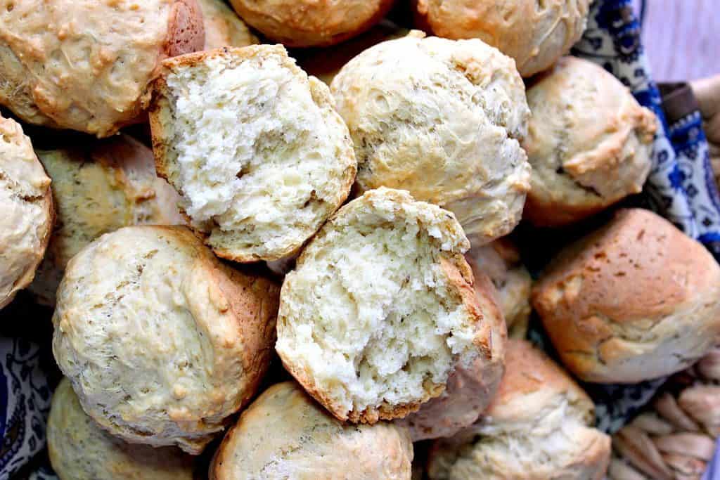 These homemade Beer Bread Biscuits with Herbs come together quickly with no shaping and no cutters. All you'll need is a bowl, spoon, and muffin tin to make these incredibly delicious and golden biscuits. Make some today! - www.kudoskitchenbyrenee.com A pile of homemade Beer Bread Biscuits.