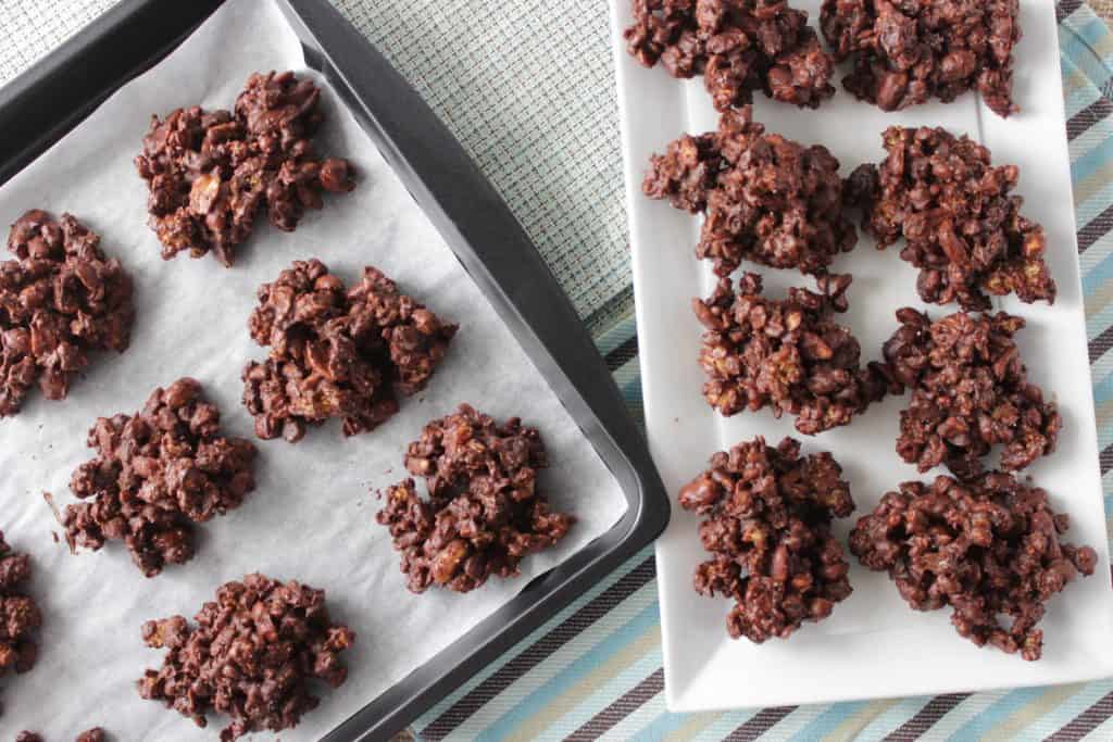 No Bake Peanut Butter and Chocolate Granola Jumbles on a platter and on a baking sheet.